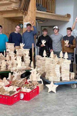 Die Schülerinnen und Schüler des Holztechnikums Kuchl mit FL Manfred Lienbacher zeigen begeistert ihre Holzdekoartikel und freuen sich, bei der Aktion mithelfen zu können. (Foto: Holztechnikum Kuchl)