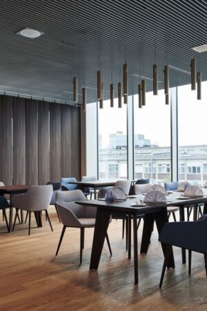 Die furnierten Bereiche harmonieren perfekt mit dem Boden, den Leuchten und dem Inventar im Gastronomiebereich von MTU München. Foto: Joachim Grothus Die furnierten Bereiche harmonieren perfekt mit dem Boden, den Leuchten und dem Inventar im Gastronomiebereich von MTU München. Foto: Joachim Grothus