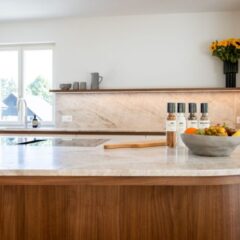 Die Maserung und die harmonische Farbgebung des Nussbaum‑Furniers bilden einen eleganten Kontrast zu den hellen Fronten der Küche. Fotos: © Davidküchen Basel